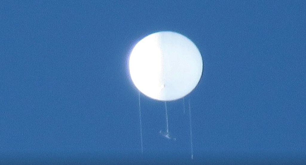 Un ballon bien rond, avec trois cordes qui pendent sur le périmètre et une nacelle rectangulaire assez longue.