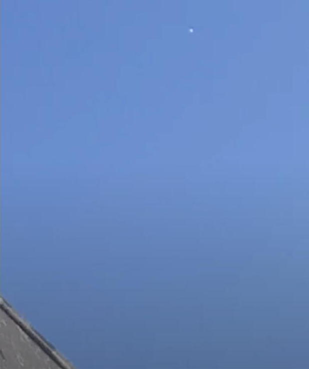 Point blanc dans le ciel, au-dessus d'un toit